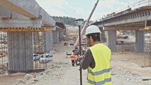 Construction engineer working with GPS equipment on a large highway construction site