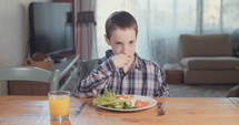 Boy refusing to eat healthy food.