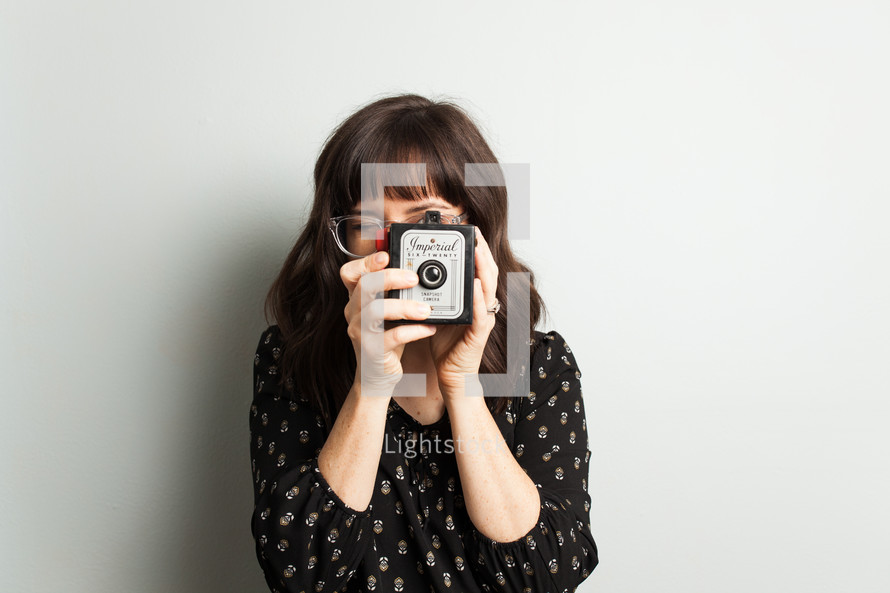 a woman holding a vintage camera 