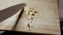 Chopped Garlic Falling From Wooden Board. Slow Motion Shot