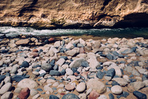 Smooth river rocks next to a flowing river.