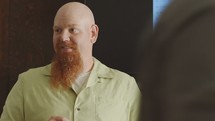 man welcoming others and speaking at a Bible study 