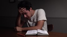 stressed man reading a Bible 