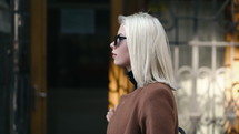 Stylish blonde woman walking in the city