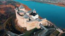 Panorama aerial view of old castle Hotin near river. Khotyn Fortress - medieval castle on yellow autumn hills. Ukraine, Eastern Europe. Architecture of Middle Ages in our time.