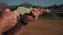 A man shooting a classic western style rifle