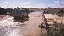 All terrain truck vehicle crosses a flooded river on a bridge after heavy rain in Morocco country
