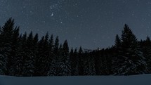 Blue Starry night sky with stars motion over snowy winter forest mountains Timelapse Astronomy
