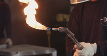 Worker lighting up a tourch in a metal workshop
