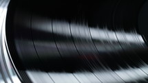 Macro textured grooves of spinning vinyl record. Music nostalgia. Perfect for visual overlays. Retro vibes, vintage aesthetics. High quality 4k footage