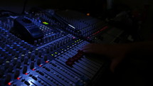 Technician working a large sound board at a live concert