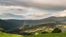 Rainbow over green rural landscape Time lapse
