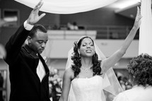 bride and groom with hands raised in praise and worship to the Lord