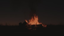 Wide shot of a large bonfire at dusk