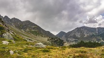 Dramatic stormy clouds moving over alps mountains in autumn nature Time lapse
