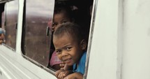 Children looking out the window in the Philippines