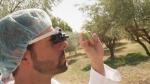 Agronomy scientist looking at an olive with special glasses