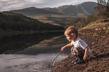 toddler playing in a lake 