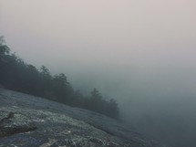 side of a sloping cliff and fog 