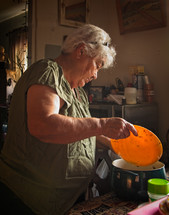 elderly woman chopping pepper 