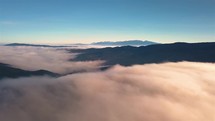 Fly above Misty Clouds motion in forest mountains sunny autumn morning nature