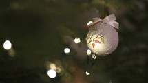 Christmas background with white hand painted ball on living Christmas tree with lighting
