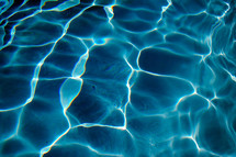 Sunlight reflecting in a swimming pool of blue chlorinated fresh water on a hot summer day.  When I see pool water with the sun reflecting its light, it makes me think of summer and relaxing on vacation. There is something calming and tranquil about the color of pool water that brings back memories of childhood and fun summers on vacation. 