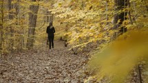 a woman walking in a fall forest 