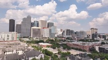 Aerial video of downtown Houston, Texas on a beautiful blue sky cloudy day with tall buildings in the background.