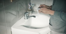 a woman washing her hands with soap 