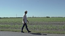 man walking down the middle of a rural road 