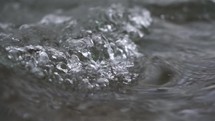 Close up of crystal clear water flowing in mountain stream river nature background Slow motion
