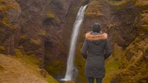 a woman watching a waterfall 