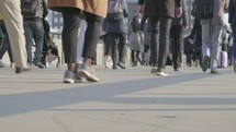 pedestrians walking across a London bridge, London - editorial use only
