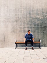 man waiting sitting on a bench 