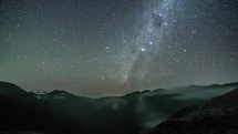 Starry night sky with milky way galaxy stars in foggy mountains Time lapse Astronomy
