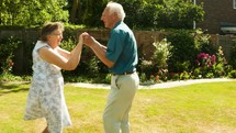 elderly couple dancing outdoors 