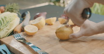 Slow motion shot of lemon slicing in an outdoor kitchen.