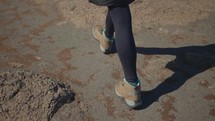 boots walking across a barren landscape 