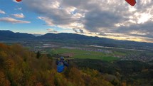 Paraglider fly above autumn forest, adrenaline adventure paragliding 
