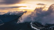 Mistyc clouds sky motion fast over alps mountais nature in spring evening at golden sunset Time lapse
