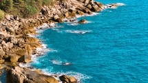 Drone aerial view over long rocky coastline. Amazing sea waves crashing on rocks seascape