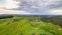 Time lapse of clouds moving over sheep farm in green countryside in New Zealand.
