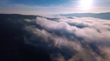 Fly above misty clouds sky, Aerial view of beautiful nature landscape in sunny autumn morning heaven 4K
