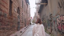 Young woman in the streets of Istanbul with Graffiti on walls
