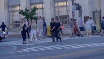 people crossing on a crosswalk in a city 