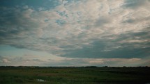 Meadow sky time-lapse video, fast moving clouds