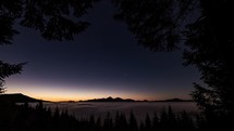 Early morning in magic forest with stars in blue sky, foggy clouds in mountains valley and beautiful colors before sunrise in wild nature landscape Time lapse
