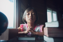 Girl praying with a Bible