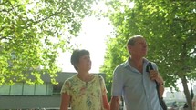 elderly caucasian couple walking holding hands 